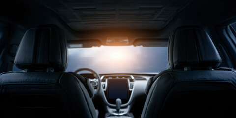 sleek, modern car interior with a focus on the front dashboard and seats, illuminated by a bright light from the windshield.