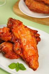 Gourmet Spiced Crispy Chicken Wings with Glaze and Mint Leaf Garnish