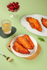 Crispy Spiced Fried Chicken Wings with Cherries on Green Background Food Photography