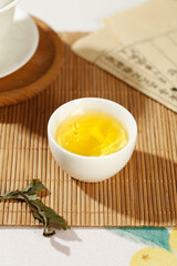 Chinese Tea Ceremony Golden Tea in White Porcelain Cup on Bamboo Mat Traditional Asian Culture