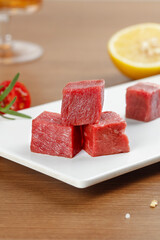 Raw Beef Cuts on White Plate with Fresh Lemon and Herbs - Premium Red Meat for Cooking