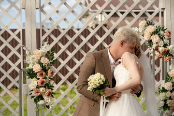 Couple shares a romantic kiss during their outdoor wedding ceremony