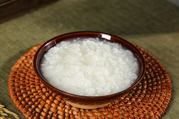 Wuchang Xiangmi Long Grain Indica Rice Varieties in Traditional Ceramic Bowl on Bamboo Placemat