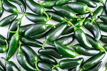 Heap of green mexican jalapeno hot peppers close up. Top view. Food photography