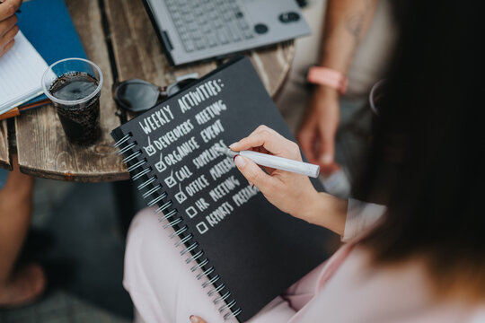 Business professionals collaborate outdoors, reviewing weekly activities, showcasing teamwork and effective planning.