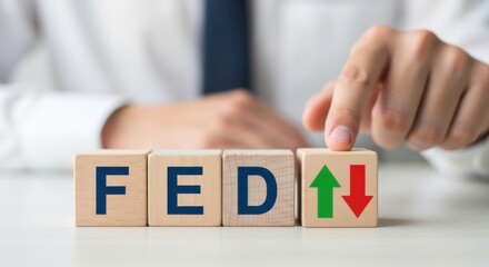 Close-up of a person's hand placing upward and downward arrows on wooden blocks spelling out FED.