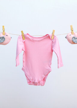 Baby clothes on a rope on a colored background.. Vertical photo format