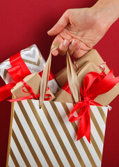Paper bag full of christmas gifts close up with place to place text. Vertical photo format