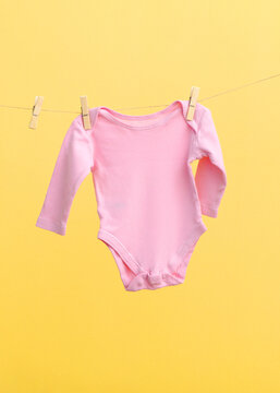 Baby clothes on a rope on a colored background.. Vertical photo format