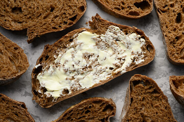 Artisan sliced rye sourdough bread with butter top view. Food backgrounds