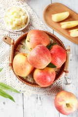 Fresh Red Gala Fuji Apples from Xinjiang in Wicker Basket with Sliced Fruit on Wooden Board
