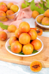 Fresh Xinjiang Apricots in White Bowls on Wooden Board - Small Orange Stone Fruits Light Background