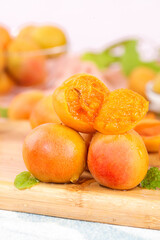 Fresh Xinjiang Apricots on Wooden Board - Ripe Stone Fruit Cut in Half Showing Orange Flesh