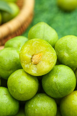 Fresh Green Sichuan Plums with Crisp Flesh - One Cut Half Showing Pit and Juicy Interior