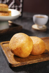 Golden Fresh Bread Rolls on Wooden Board with Coffee Background