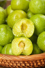 Fresh Green Plums in Basket - Ripe Stone Fruit with Crisp Texture and Natural Sweetness