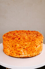 Delicious layer cake with vibrant orange topping on display at a bakery