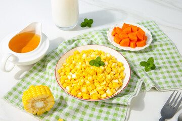 Fresh Golden Corn Kernels with Milk and Vegetables on Green Checkered Tablecloth
