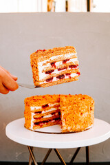 Delicious homemade layer cake served on a white table in bright indoor setting