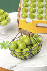 Fresh Green Plums in Wire Basket - Crisp Summer Fruit Storage and Kitchen Organization
