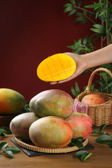Fresh Ripe Mangoes with Sliced Fruit Display - Tropical Produce Arrangement with Green Foliage