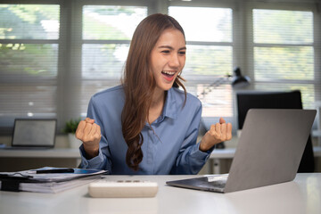 Happy woman cheering after achieving business goal or financial result.