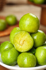 Fresh Green Plums in Bowl - Healthy Stone Fruit Display with Cut Half Showing Pit