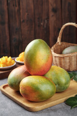 Large Fresh Mangoes from Panzhihua China on Wooden Board with Basket - Premium Tropical Fruit Photography