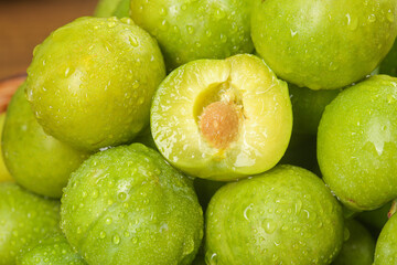 Fresh Sichuan Plums with Water Drops on Wood Background - Crisp Green Stone Fruit