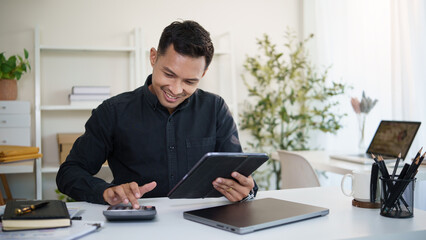 Smiling accountant using digital tablet and calculator to manage financial data in modern office.