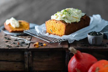 Pumpkin bread with cream topping on rustic wooden background