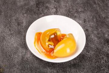 Raw Egg Yolks with Yellow Centers in White Bowl on Dark Surface