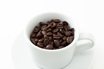 コーヒーカップに入ったコーヒー豆　白バック