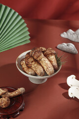 Fresh Matsutake Mushrooms in White Bowl on Red Background for Gourmet Cooking and Food Preparation