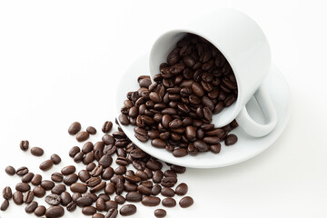 コーヒーカップとこぼれたコーヒー豆　白バック