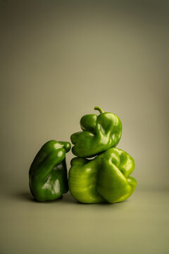 Naklejki Artistic abstract still life of green bell peppers with surreal organic shapes, sculptural vegetable stack, creative minimal food photography, concept, healthy eating, balancing structure