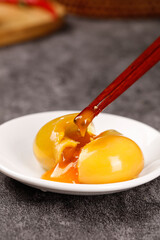 Raw egg yolks with chopsticks on white plate - fresh yellow eggs for cooking and baking ingredients