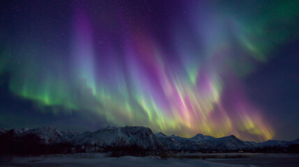 Naklejka premium Medium shot of northern lights glowing in vibrant green and purple waves across a crystal-clear sky, landscape below bathed in luminous light.