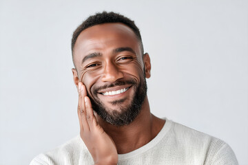 Handsome Black man with a charming smile touches his face, radiant and confident in his own skin
