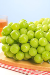 Fresh Green Seedless Grapes Bunch on Wooden Board with Orange Juice Glass - Healthy Organic Fruit Snack
