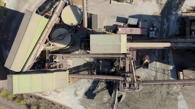 Aerial drone view of huge quarry mining operational facility, extracting rare earth minerals, heavy plant machinery and industrial conveyor belts in Coalville England UK sunny 