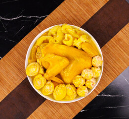 Golden turmeric chicken with cauliflower on white plate - healthy spiced meal preparation on bamboo mat