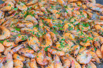 Fried Shrimp with Herbs. Fried shrimp with garlic and herbs sizzling in oil, creating a vibrant and flavorful seafood dish. Concept of shrimp dish, street food and coastal cooking