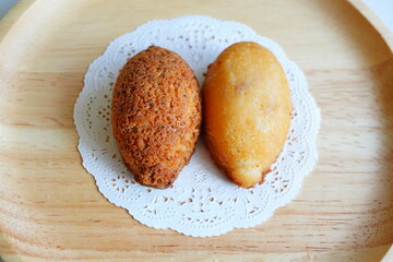 Two pieces of lemon and lemon tea flavored financiers served on a plate, freshly baked moist French style cakes, popular as a sweet gift and hotel buffet dessert