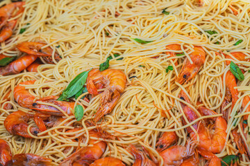 Spaghetti with Shrimps. Close-up of spaghetti pasta mixed with whole shrimp and fresh basil leaves. Concept of seafood pasta, Mediterranean cuisine, gourmet food