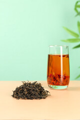 Fresh Golden Longjing Tea Leaves and Brewed Cup - Traditional Chinese Tea Ceremony Setup with Natural Green Background