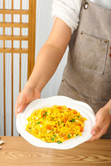 Golden Scrambled Eggs with Sweet Corn Kernels on White Plate in Kitchen