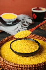 Yellow Millet Grains in Wooden Spoon and Bowl - Nutritious Breakfast Ingredient for Congee