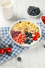 Healthy oatmeal yogurt breakfast bowl with berries and nuts for weight loss diet on white wooden table