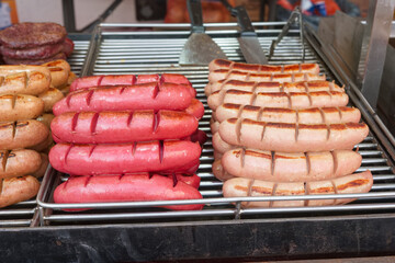 Grilled sausages on display at a street vendor in a bustling market